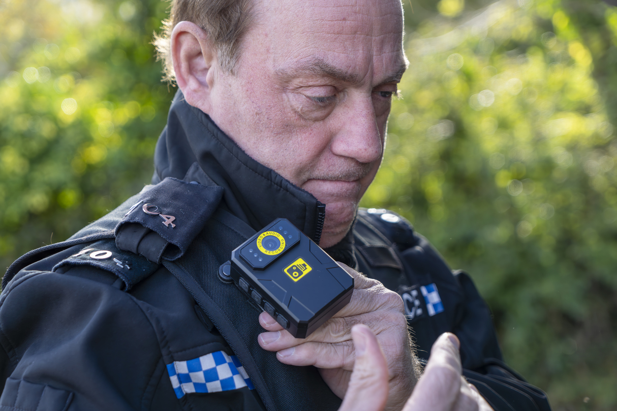 UK police officer fitting his radio to his stab vest.