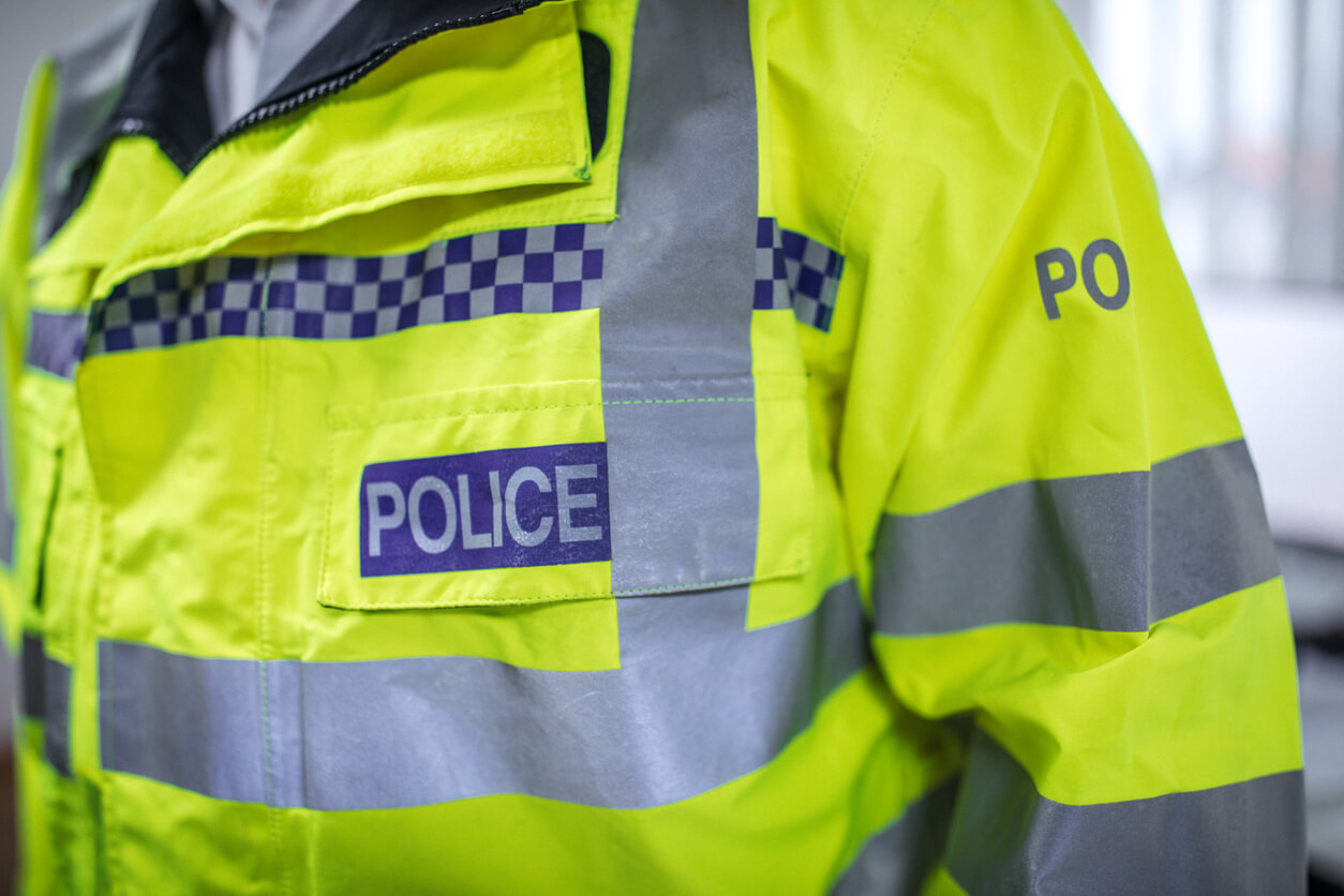 Up close image of a police officer wearing a high visibility neon yellow police jacket