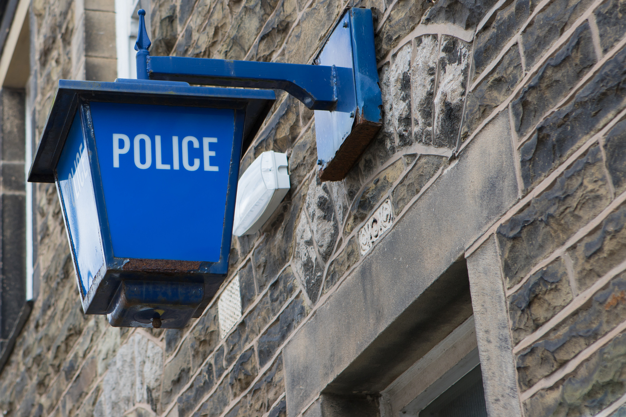 Vintage police lantern on an old stone wall outside a police station