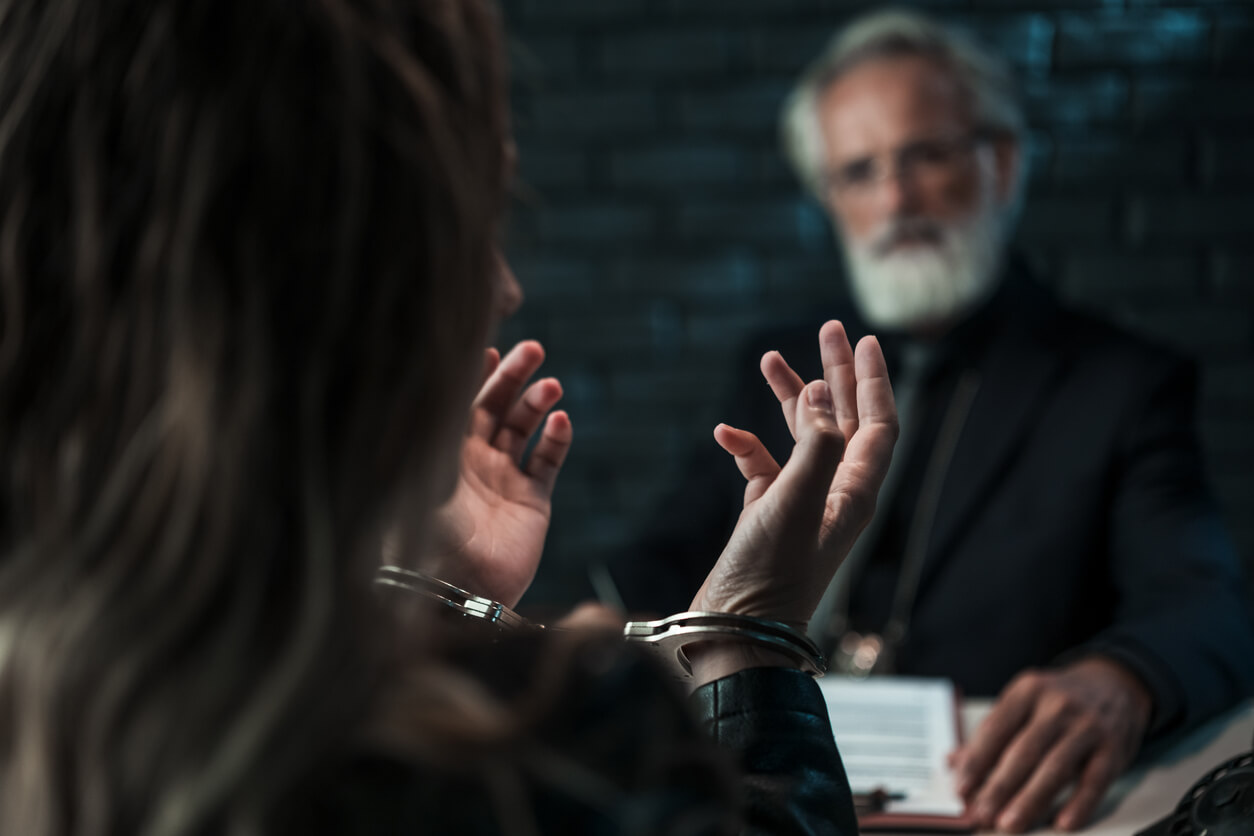 Picture of a police officer interviewing a woman in handcuffs