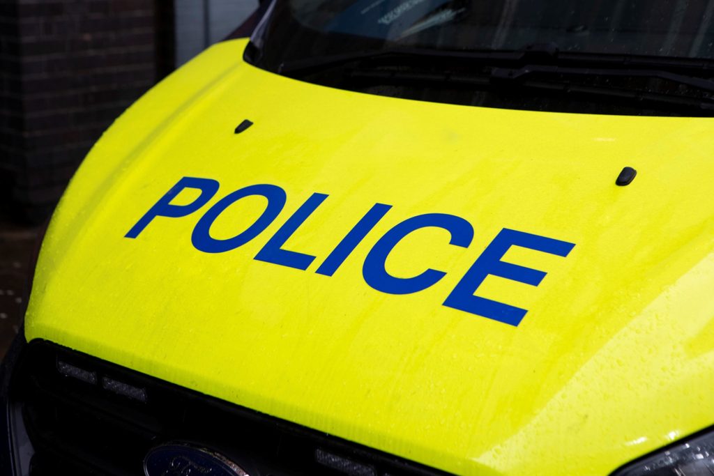 Close up on the word police located on the bonnet of a police van