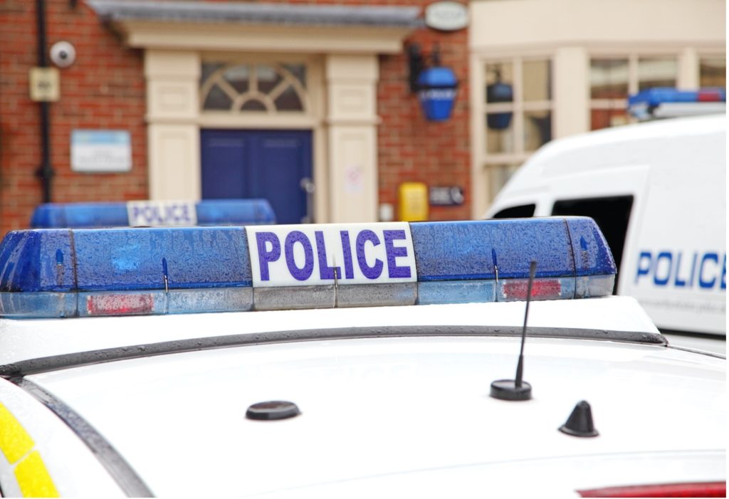 Up close photograph of a blue police light on top of a police car