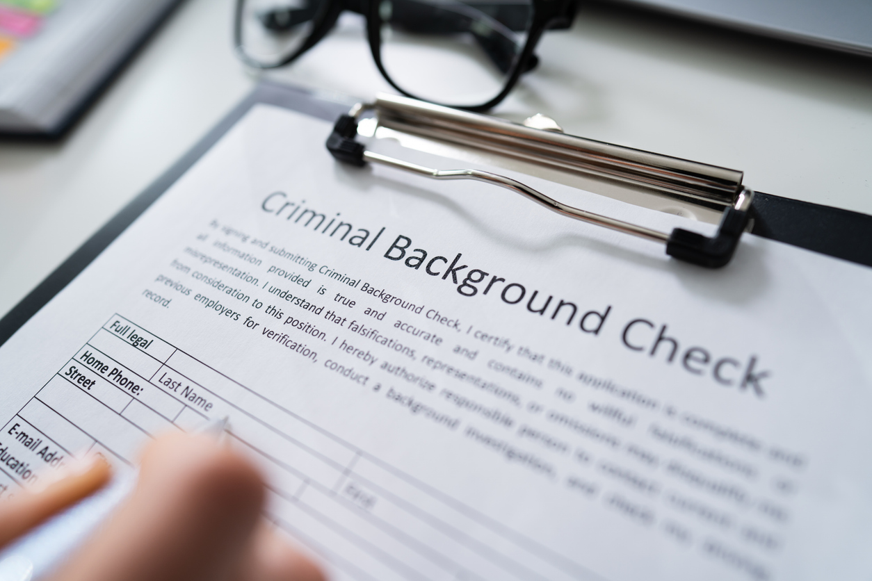 Close-up Of Person Hand Filling Criminal Background Check (DBS Check) Application Form With Pen