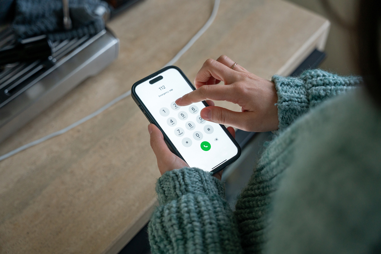 Close-up of a woman dialling the emergency number 112 on her smartphone
