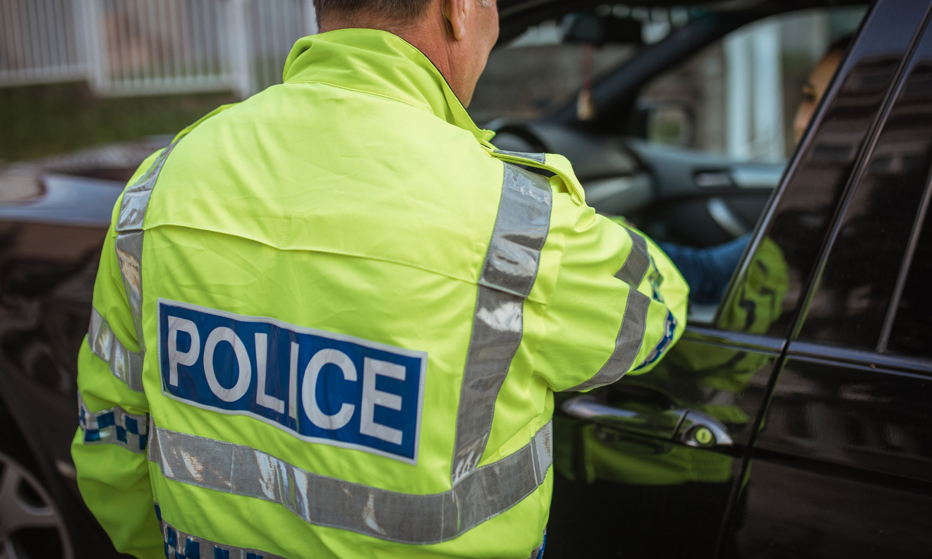 Young woman pulled over by police officer on the road.