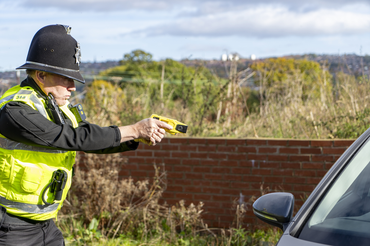 UK police officer holding a taser.